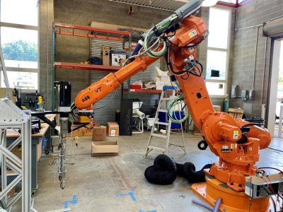 Large orange 3-D robot arm.